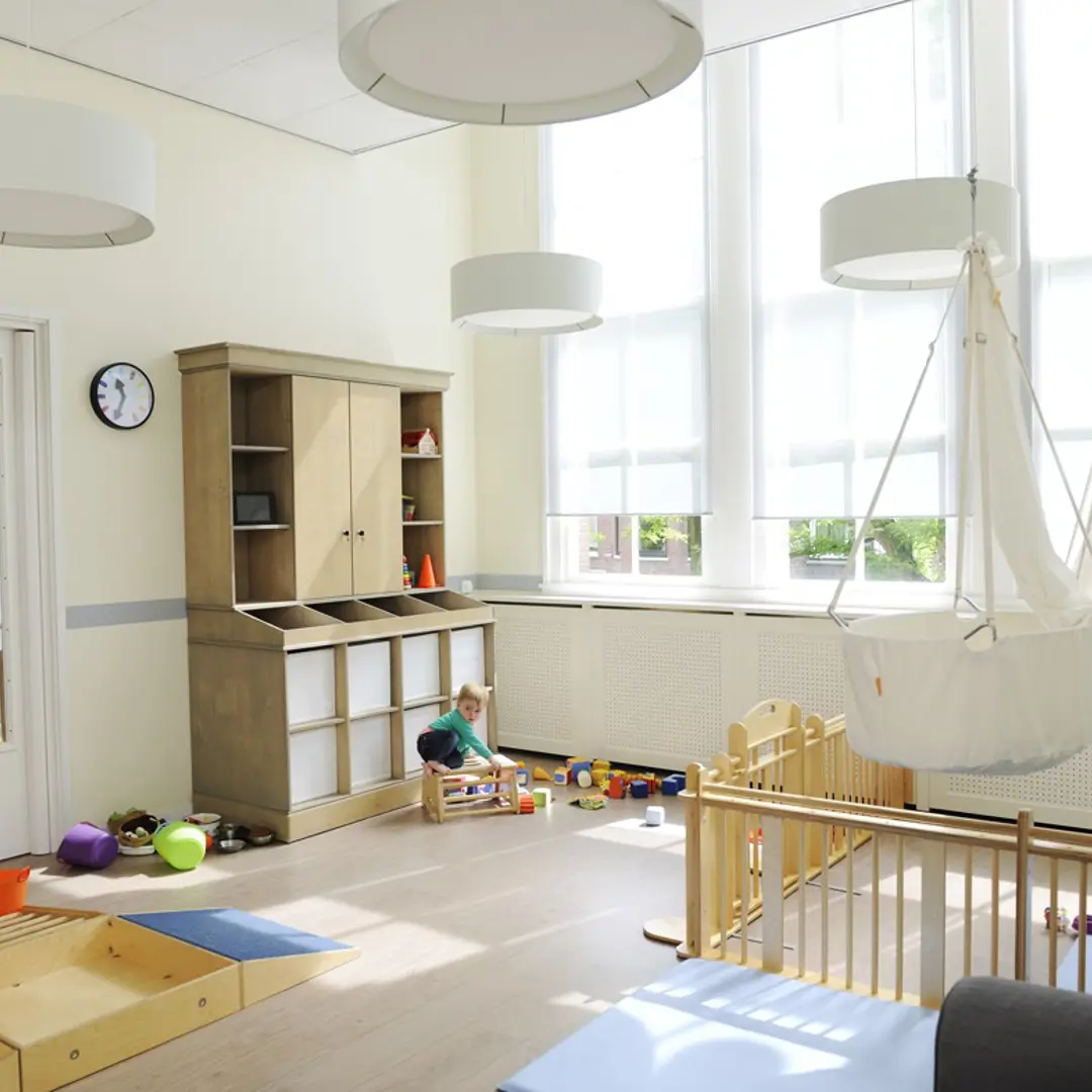 kind speelt met houten speelgoed op de babygroep