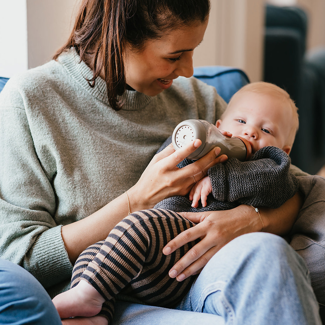 Werken bij CompaNanny nanny geeft baby fles