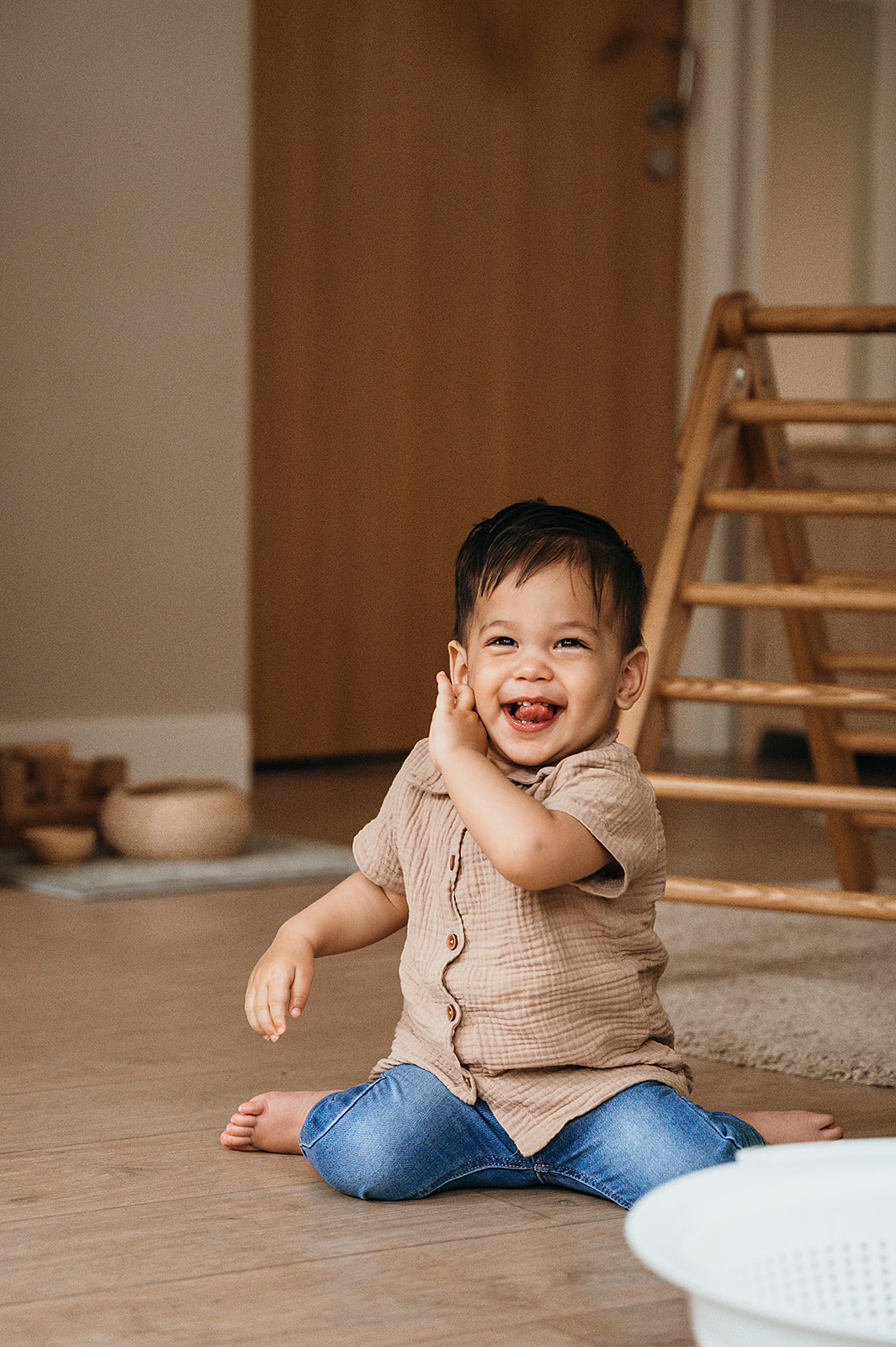 Dreumes zit op de grond en lacht naar camera