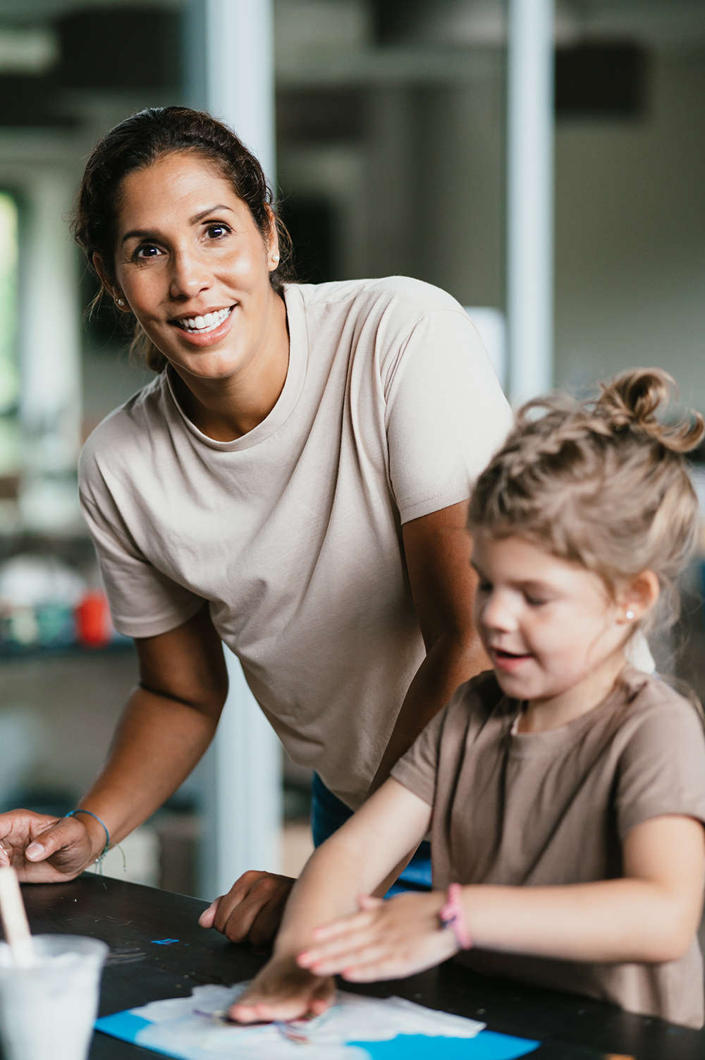 Vrouw knutselt met kind aan tafel