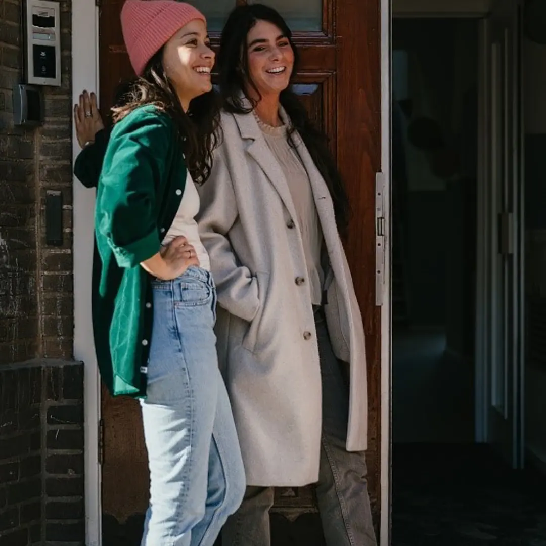 Twee vrouwen staat naast elkaar en lachen