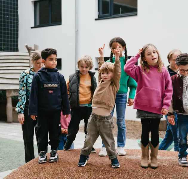 Groep kinderen staat in tuin van kinderopvang