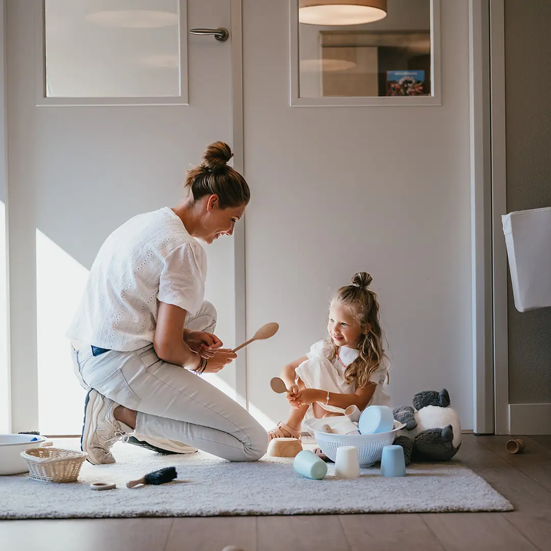 Vrouw en kind spelen op de grond