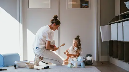 Vrouw en kind spelen op de grond