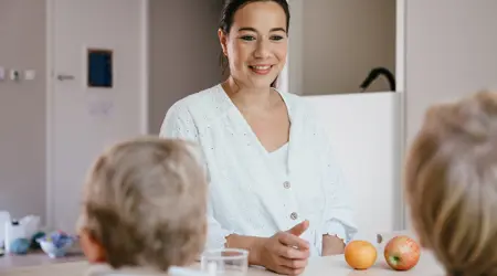 Werken bij CompaNanny Pedagogisch Medewerker eet fruit met kinderen op kinderopvang
