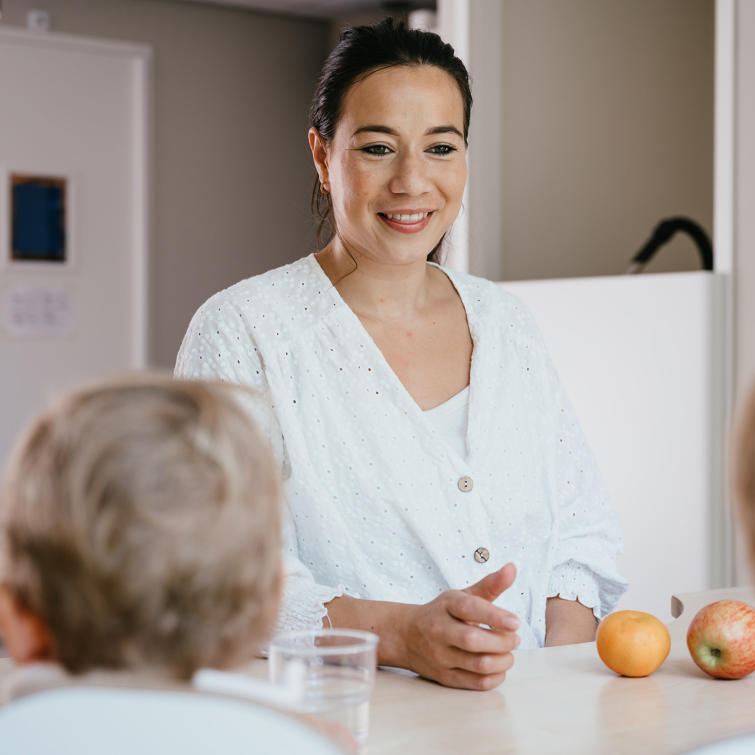 Werken bij CompaNanny Pedagogisch Medewerker eet fruit met kinderen op kinderopvang