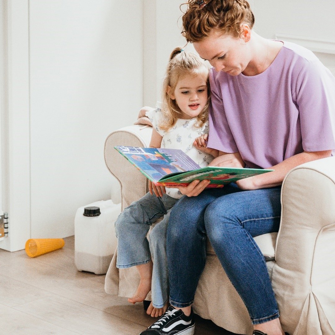 Pedagogisch Medewerker leest boekje samen met kind