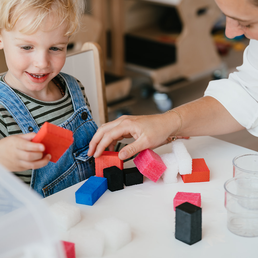 Kind en vrouw spelen met blokken aan tafel