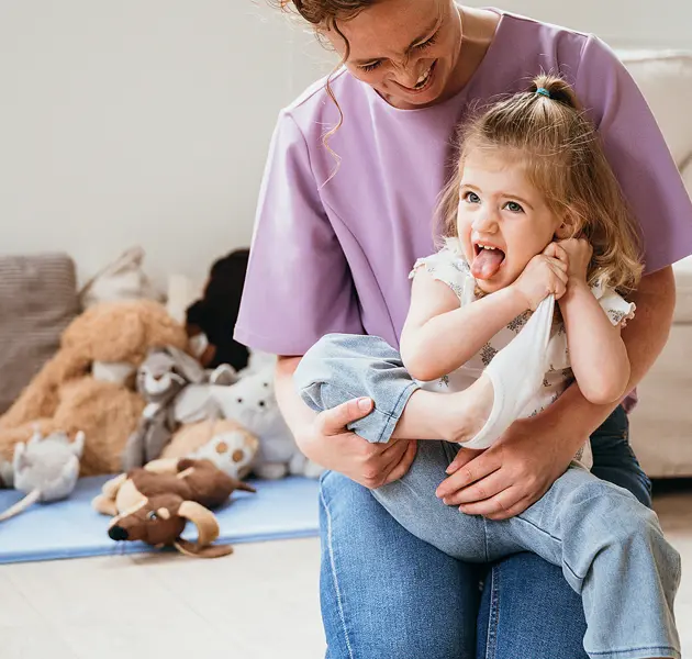 Meisje zit op schoot bij vrouw en trekt sok uit