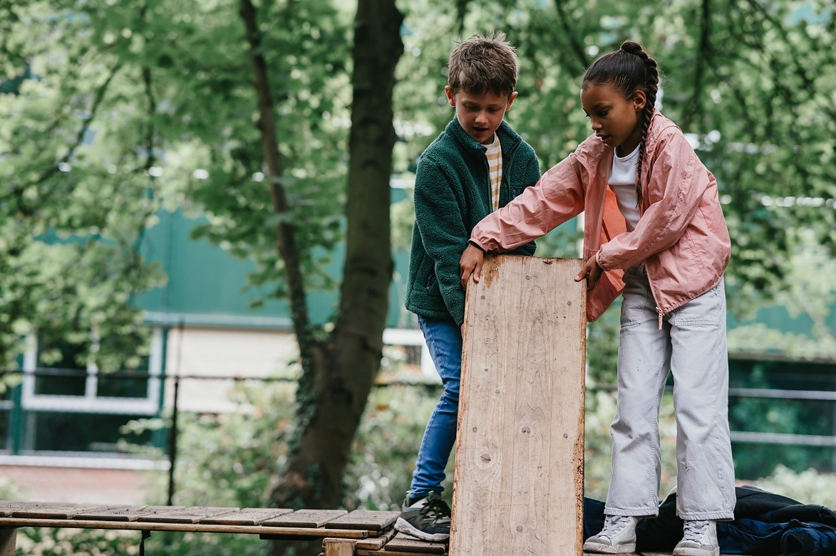 Jongen en meisje houden houten plank vast