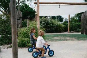 Werken Bij Compananny Kinderopvang Kinderen Zitten Op Fiets Tuin