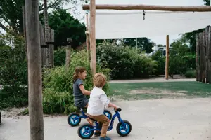 Werken Bij Compananny Kinderopvang Kinderen Zitten Op Fiets Tuin