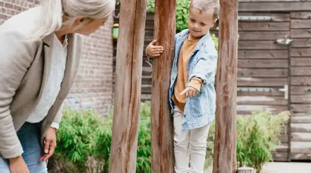 Pedagogisch Medewerker en kind buiten spelen